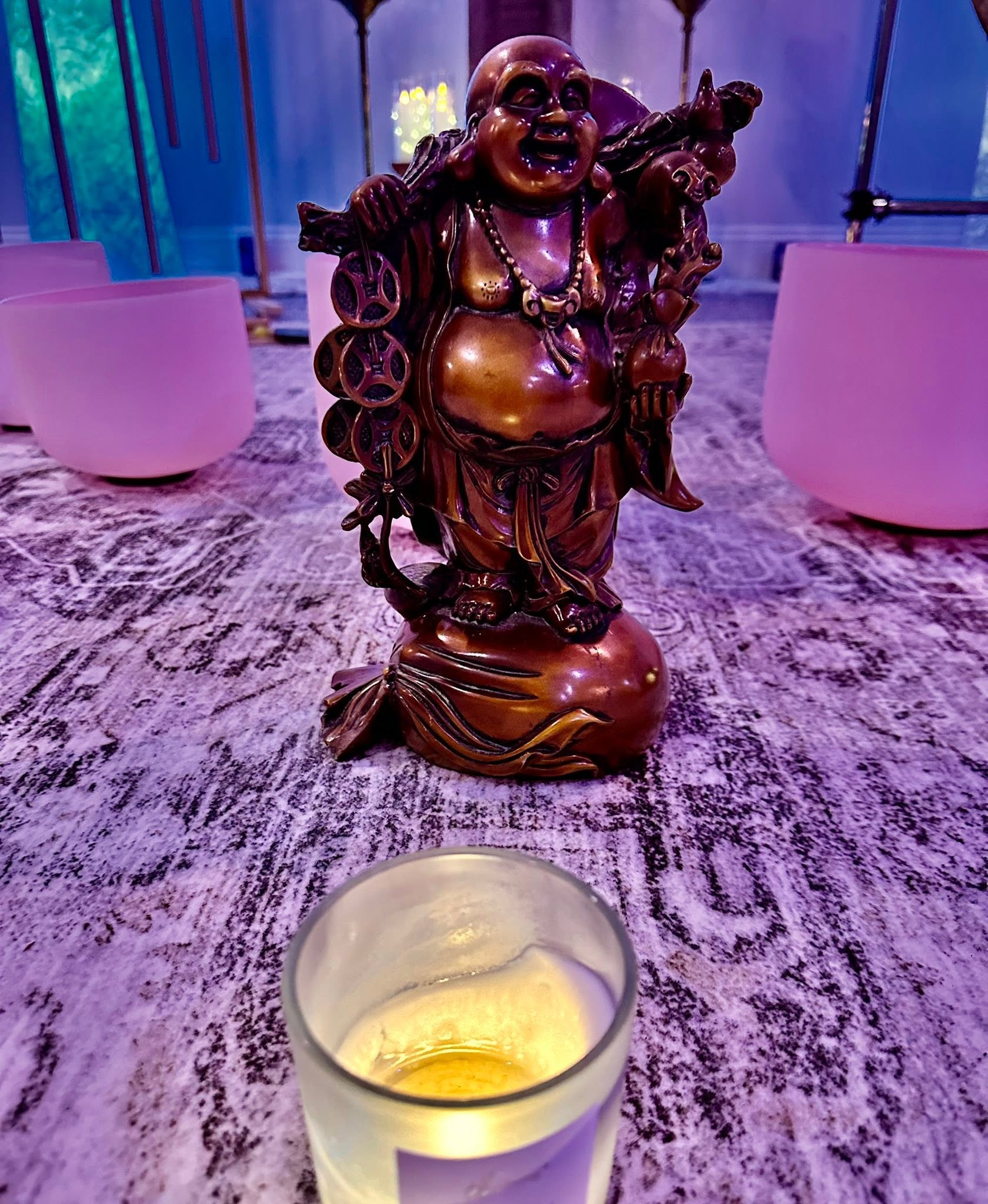 A candle and statue in a sound bath setting